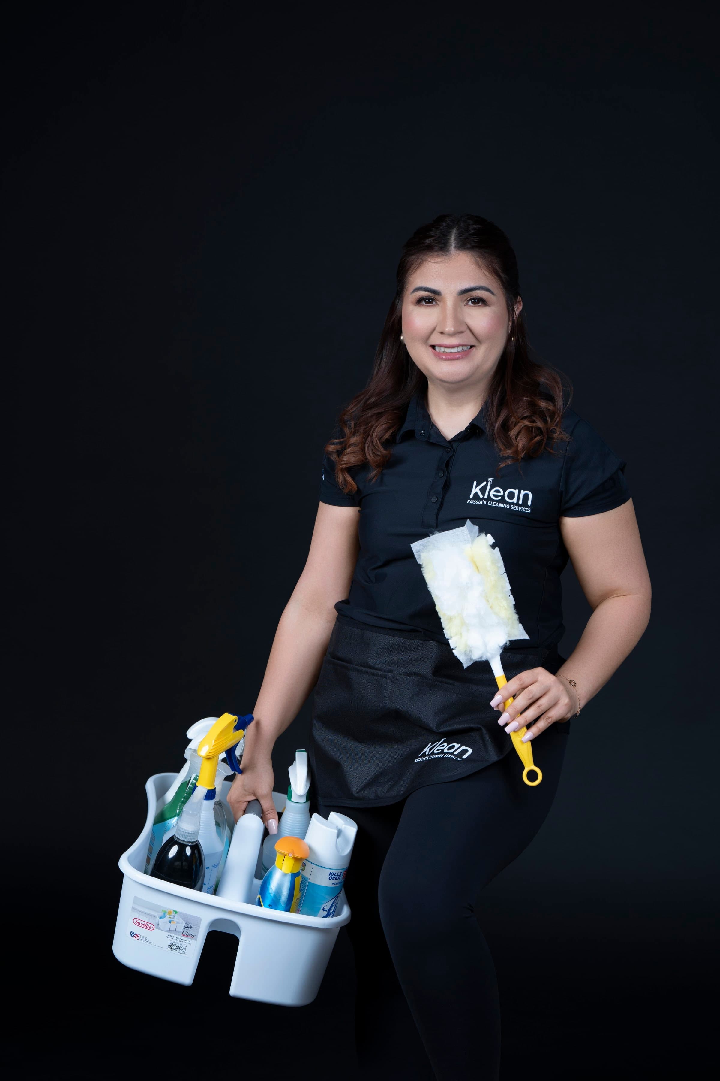 Krissia García con el uniforme de Klean, sosteniendo el carrito de limpieza y un plumero